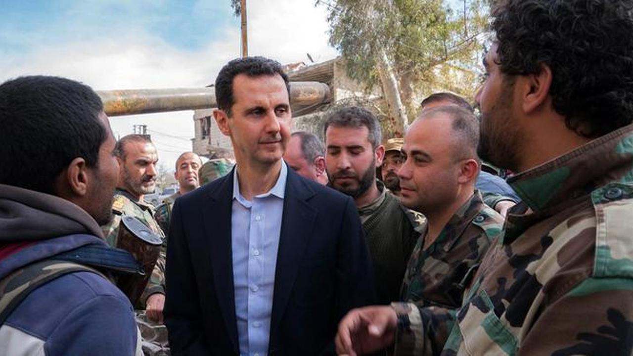 Presiden Suriah Bashar al-Assad berbincang dengan pasukan pemerintah di garis depan wilayah Ghouta Timur, Minggu (18/3). Ini adalah pertama kalinya Assad mengunjungi daerah ini selama bertahun-tahun. (HO/SYRIAN PRESIDENCY FACEBOOK PAGE/AFP)
